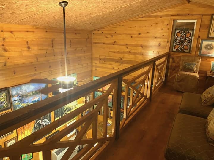 The loft railing is opposite the bed upstairs yet keeps guest privacy with an open feel.  The warm wood is Ponderosa pine and the flooring is laminate.