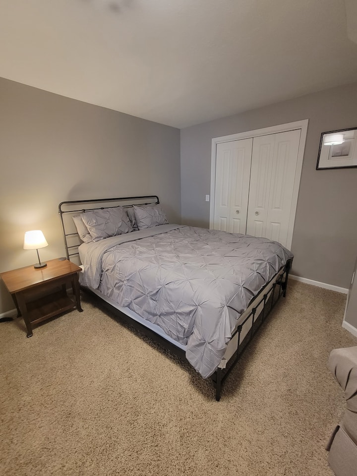 ห้องนอนชั้นใต้ดิน #4 พร้อมเตียงขนาดใหญ่และหน้าต่างทางออกในชั้นใต้ดิน