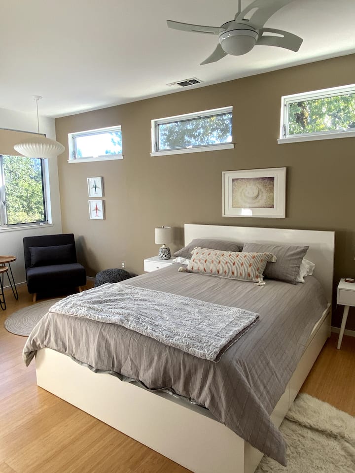 El dormitorio principal incluye una cama tamaño queen, un televisor inteligente y una zona de estar. También hay una gran luz natural. 