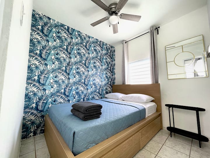 Gemütliches zweites Schlafzimmer mit einem bequemen Bett, Deckenventilator und ideal für Alleinreisende, Jugendliche oder flexible Schlafgelegenheiten. Kleines Schlafzimmer mit Weitwinkelansicht.