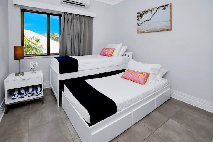 Segundo dormitorio: habitación luminosa y espaciosa con dos camas individuales y decoración tropical para la máxima relajación.