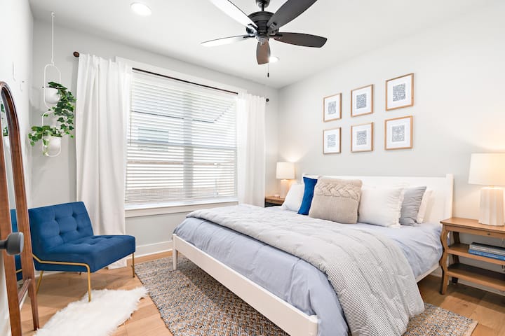 El primer dormitorio de invitados con una cama tamaño king tiene un espejo de piso y ropa de cama acentuada de Pottery Barn.  ¡Estas camas son tan cómodas!