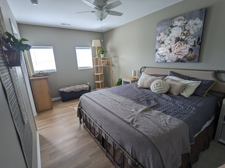 Dormitorio principal con cómoda cama tamaño king. Lámparas ajustables a cada lado de la cama (luz cálida o luces de lectura brillantes), ventilador de techo y puerta de granero construida a medida.