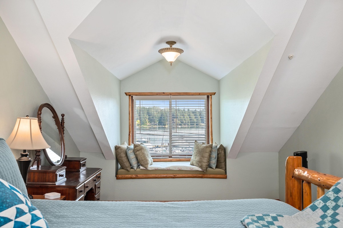 北卧室配有标准双人床、手工被子和阅读角落，可欣赏海湾日出。 