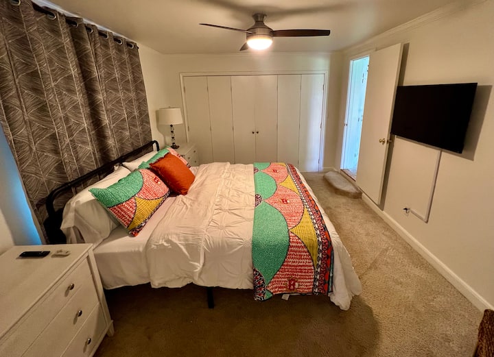 Მთავარი საძინებელი დიდი საწოლით, 2 კომოდითა და 55 დიუმიანი ბრტყელეკრანიანი ტელევიზორით.  