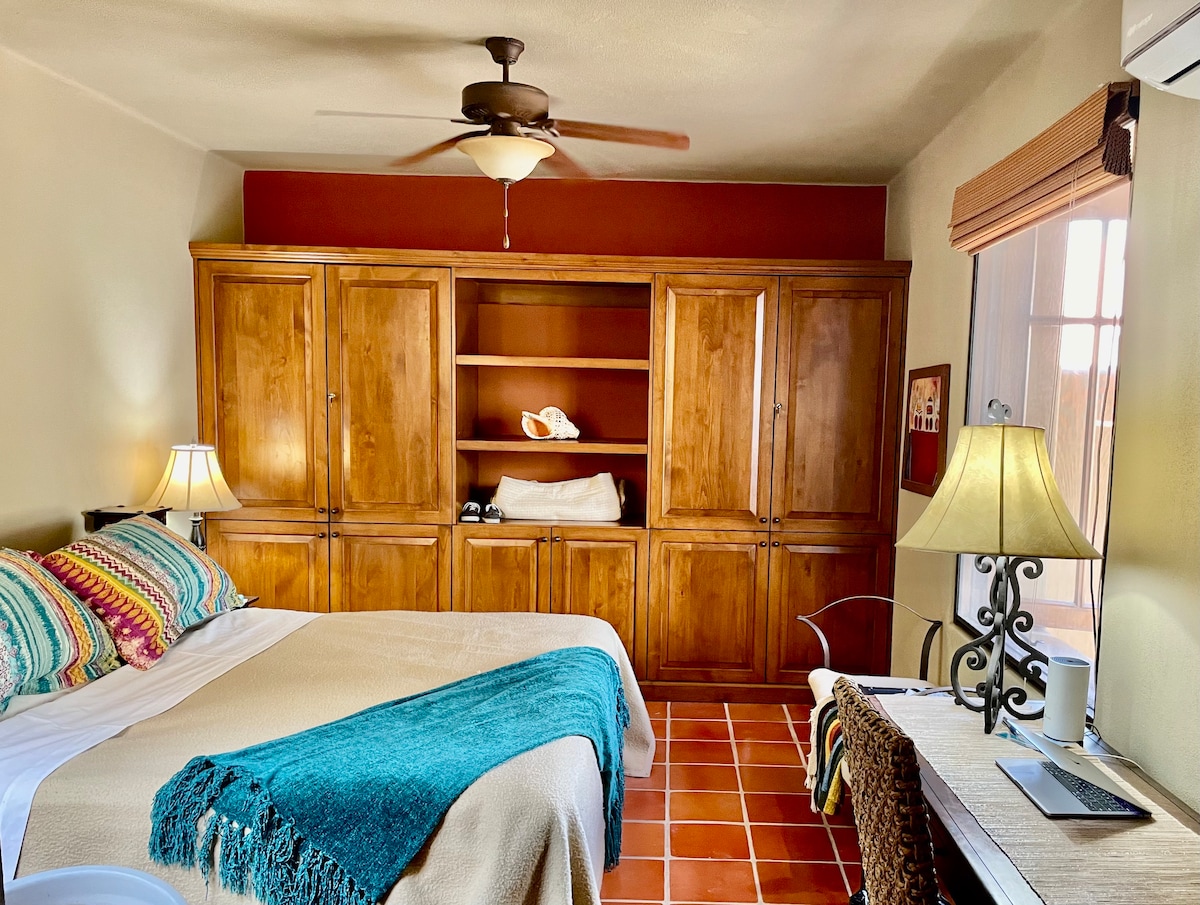 Spavaća soba na katu s udobnim bračnim krevetom, novim Smart TV-om, novim klima-uređajem, uredskim prostorom za rad i kupaonicom.