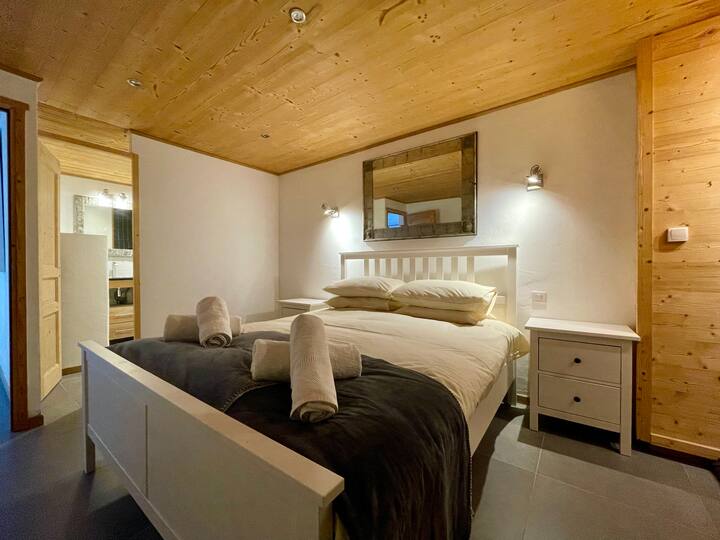 Dormitorio principal con área de armario y baño privado.