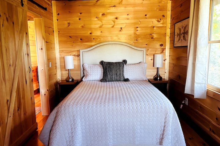 The top queen room has a queen sized bed and both bedrooms on the top flor have sliding farm doors. This bedroom may be the smallest, but it also has a private balcony attached with the best views in the house. 