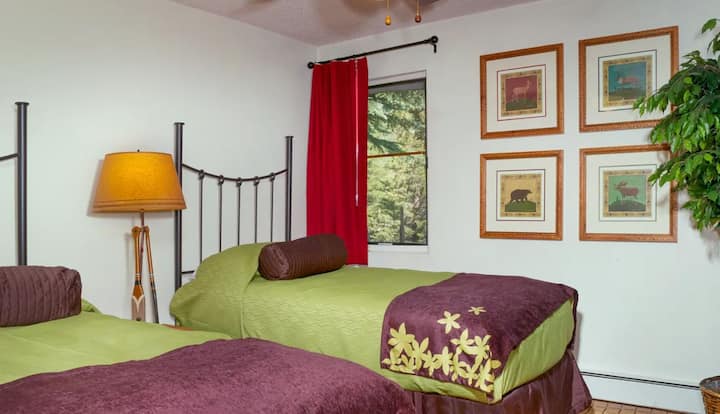 Სასტუმრო საძინებელში დგას ორი ერთადგილიანი საწოლი დასაძინებლად   და კომფორტისთვის