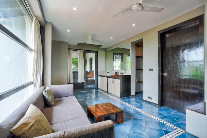 Your private Living Room with couch seating and Kitchenette having induction cooktop, Fridge, Microwave, etc. Living Room leads to patio with swimming pool.