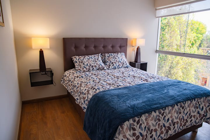 El dormitorio principal con una cómoda cama Queen con vista al parque, walk in closet y baño privado