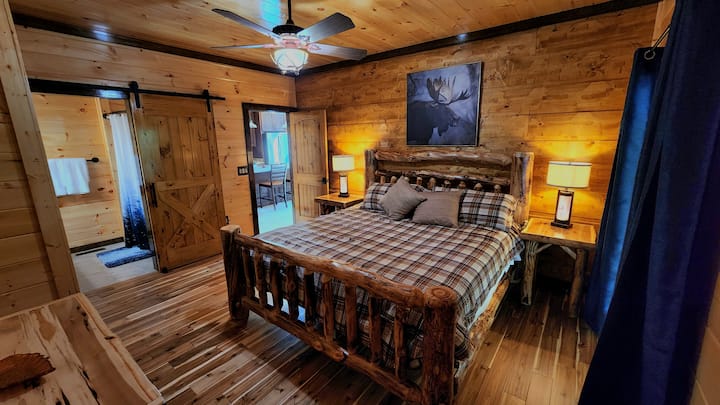 تتميز غرفة النوم في الطابق الرئيسي بسرير كبير الحجم وأثاث خشبي جميل من الأميش أسبن. استمتع بمرتبة عالية الجودة لقضاء ليلة مثالية. تحتوي غرفة النوم على أبواب زجاجية منزلقة تفتح على السطح العلوي، مما يوفر اتصالًا سلسًا بالهواء الطلق.