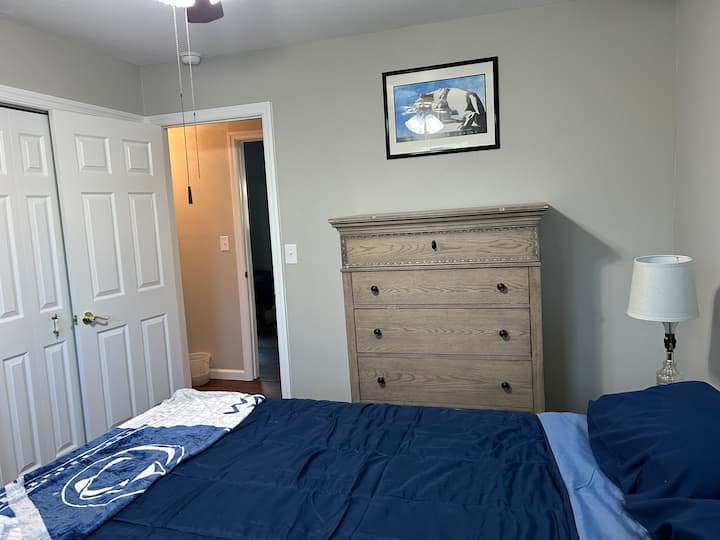 غرفة نوم ثانية بسرير بحجم كوين وخزانة ملابس وتلفزيون وخزانة ملابس واحدة.