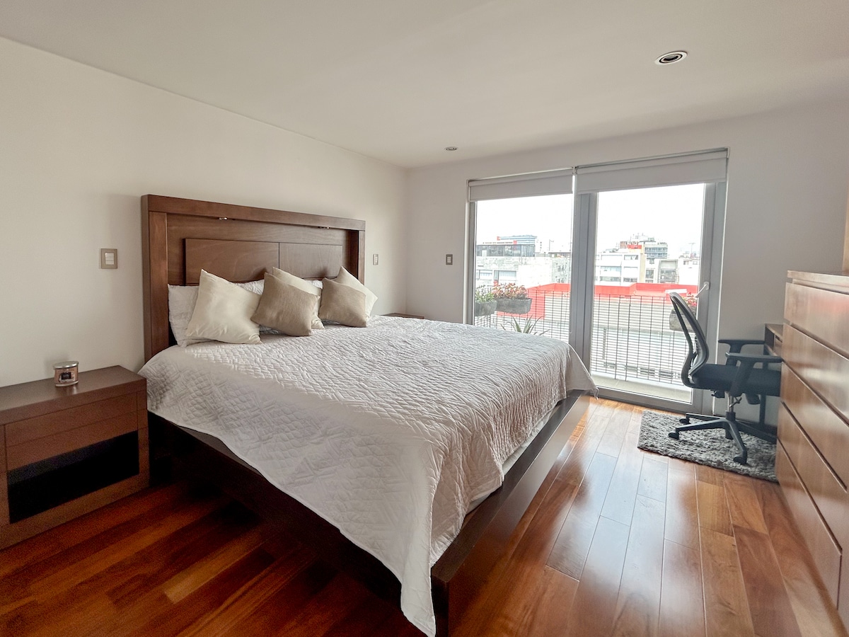 Луксозно уединение в основната спалня. Насладете се на почивни нощи в кралското легло и се събудете в града от собствения си балкон.