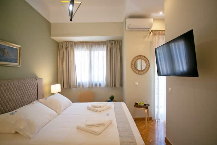 Dormitorio con unidad de aire acondicionado, televisor inteligente y escritorio de trabajo.