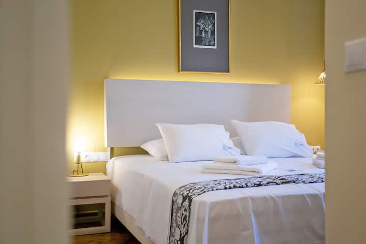 Dormitorio con unidad de aire acondicionado, televisor inteligente y escritorio de trabajo.