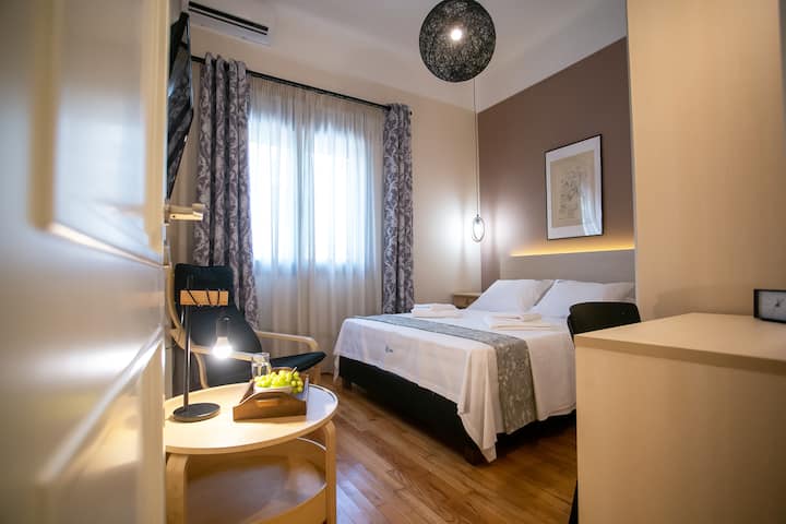 Dormitorio con unidad de aire acondicionado, televisor inteligente y escritorio de trabajo.