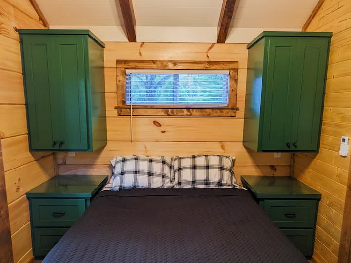 เปิดตัวโอเอซิสห้องนอนในเคบินบ้านเล็กหลังนี้ซึ่งได้รับการออกแบบอย่างชาญฉลาดด้วยโซลูชั่นการจัดเก็บในตัวมากมายทำให้ที่พักของคุณเป็นระเบียบ การออกแบบที่ชาญฉลาดช่วยให้มั่นใจได้ถึงความเป็นระเบียบเรียบร้อยในสถานที่พักผ่อนในห้องนอนที่มีขนาดกะทัดรัดแต่เงียบสงบ