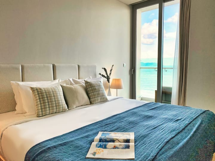 Dormitorio principal con balcón, vistas al mar, escritorio para trabajar con vistas al mar y una cómoda silla