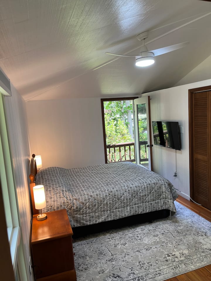 Dormitorio principal con cama queen, TV y baño privado. 