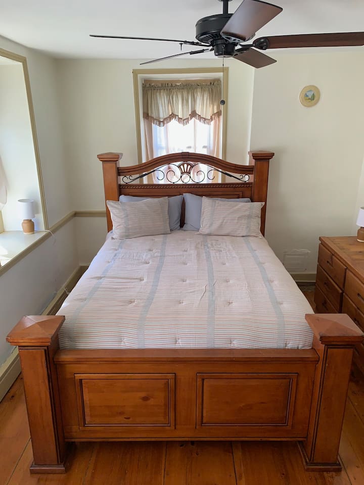 El dormitorio #2 también tiene una cama tamaño queen y dos tocadores.  Esta habitación recibe luz por la mañana y por la tarde, y tiene vistas al estanque por las ventanas delanteras y a la base del granero por la ventana detrás de la cama.