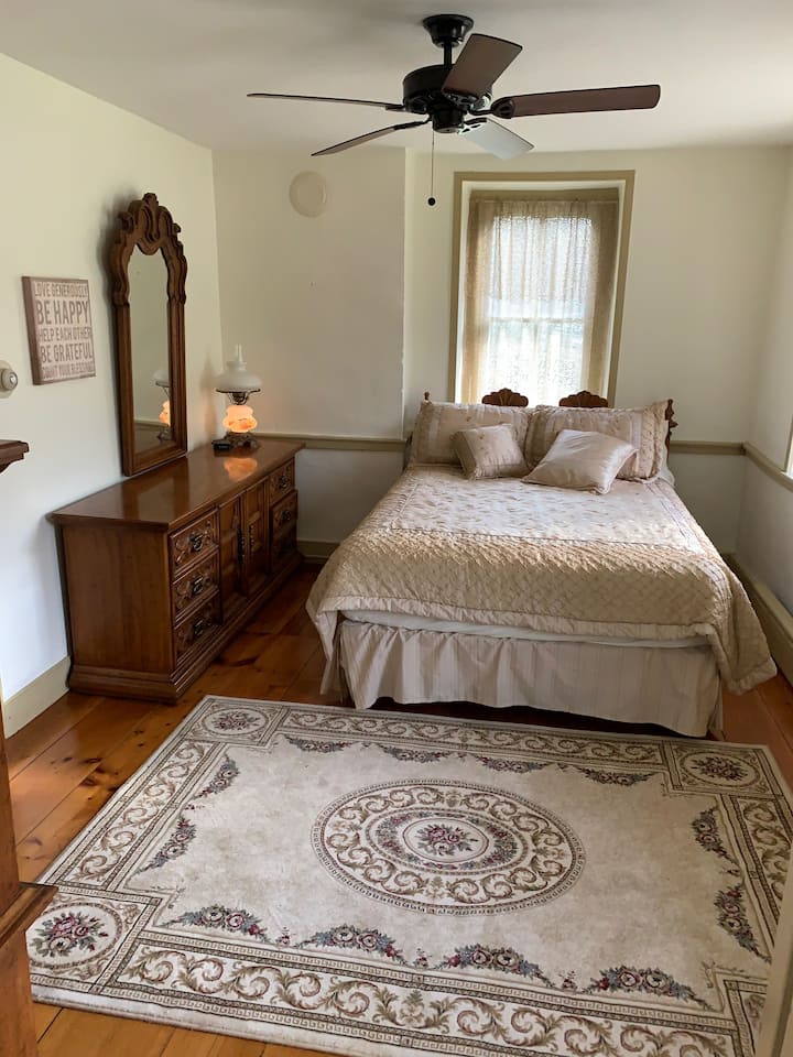 El dormitorio 1 recibe la luz del sol de la mañana y tiene vistas al estanque y al patio lateral.  Despiértate con una vista impresionante de la belleza de Pensilvania.