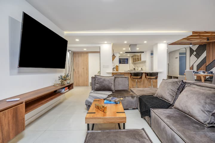 Დაისვენეთ ჩვენს შთამბეჭდავ საცხოვრებელ სივრცეში, სადაც დიდი დივანი და უზარმაზარი ტელევიზორი იდეალურ დასვენებას ქმნის.