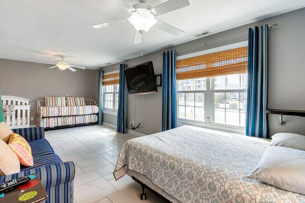 ห้องนอนชั้นแรกพร้อมเตียงเด็กอ่อนและเตียงเสริมพร้อมห้องน้ำในตัว