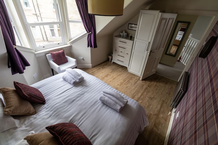 ห้องนอนชั้นบนด้านหน้าเตียงซูเปอร์คิงไซส์หรือเตียงแฝด