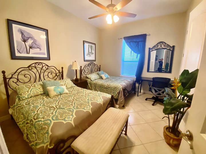 Guest room features two full-sized beds, TV and dedicated workspace