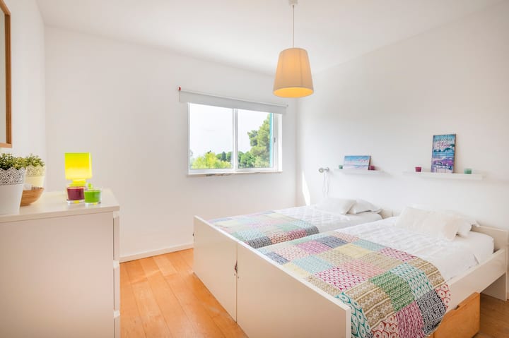 Spavaća soba s dva kreveta za jednu osobu i klima-uređajem.