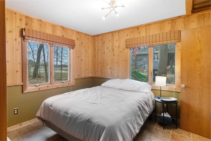 ห้องนอนชั้นล่างพร้อมเตียงควีนไซส์ หน้าต่างที่มีเฉดสีทึบ