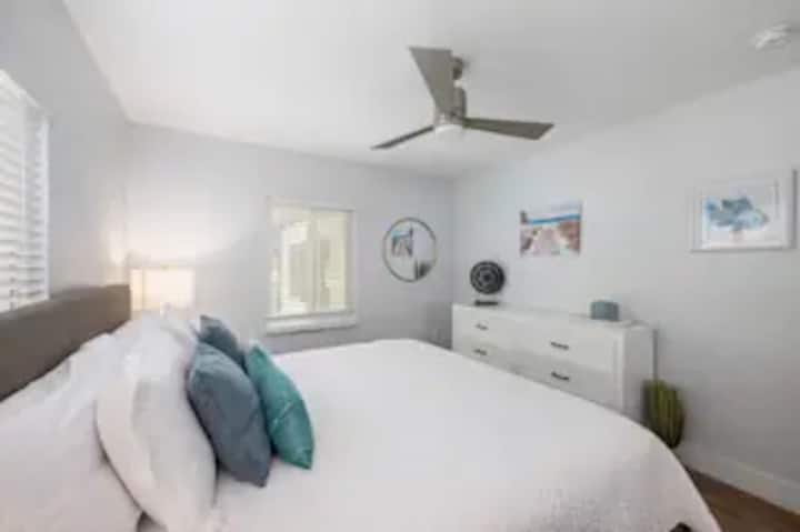 Հանգստացեք համերաշխ թագավորական ննջասենյակում, որտեղ կա սպիտակ, մաքուր դիզայն, առաստաղի օդափոխիչ, ընդարձակ պահարան և զգեստապահարան ՝ ձեր հագուստը կոկիկ պահելու համար ։