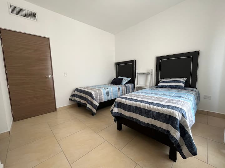 חדר שינה עם שתי מיטות יחיד וחדר רחצה פרטי