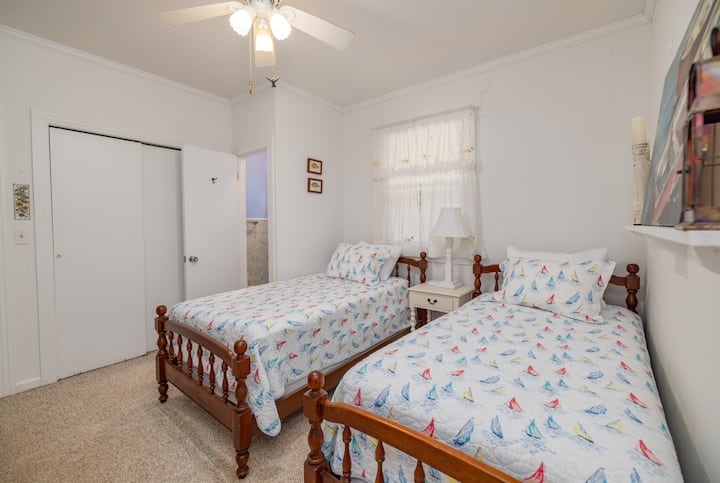 Two single beds, ceiling fan, and access to a shared 1.2 bath.