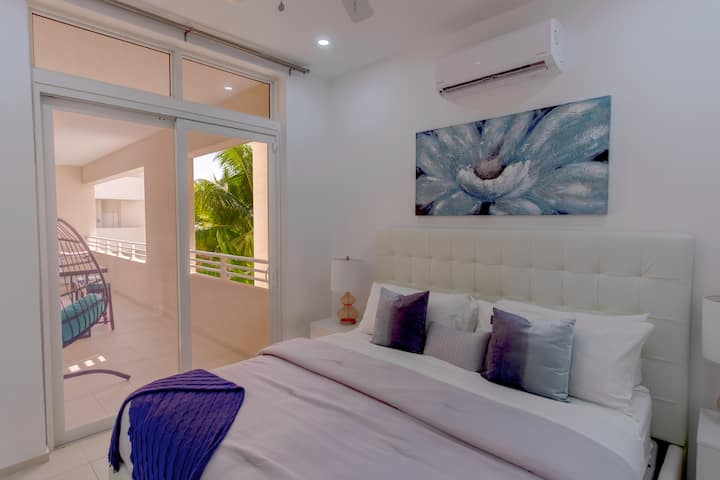 Master Suite Bliss: Relaxe em uma aconchegante cama king size com acesso direto ao pátio. Comece o dia com conforto, pisando no pátio para saborear as belas vistas do Harmony Hall Green
