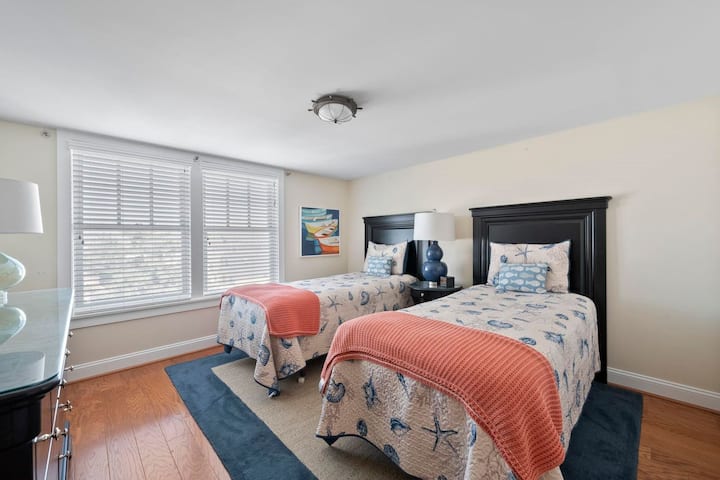 Tercer dormitorio con dos camas individuales.  Junto al pasillo, baño completo y bañera. 