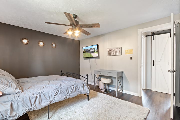Quarto principal com cama queen size e TV