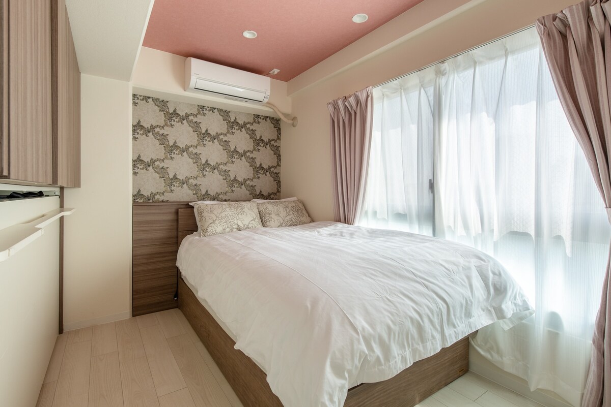 Krevat prej pelushi pranë dritareve
