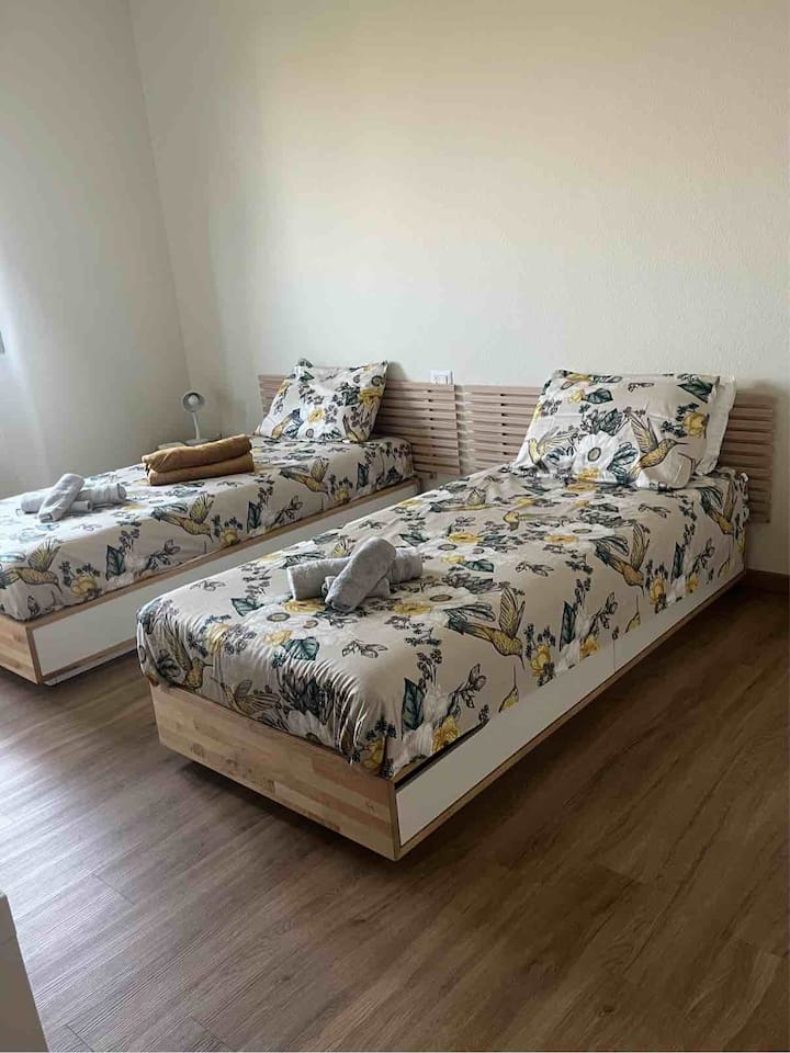 غرفة نوم كبيرة بسريرين مفردين بالإضافة إلى سرير قابل للطي.