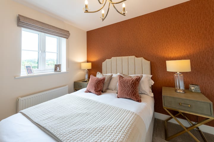 Oddýchnite si v tejto druhej spálni s manželskou posteľou, ktorá je zariadená v rovnakom štýle útulnej elegancie – mäkká posteľná bielizeň, teplé osvetlenie a príjemný dekor pre pokojný spánok.