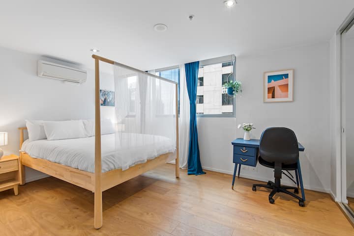 Dormitorio tamaño Queens con espacio de trabajo exclusivo. El aire acondicionado, las persianas opacas, el amplio piso y el armario se sumarán a tu comodidad.