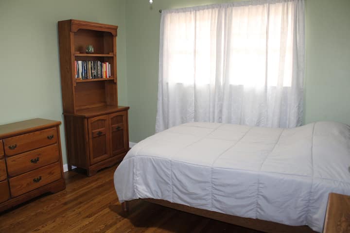 Kitanda na kabati la ukubwa kamili. Furahia kusoma mojawapo ya vitabu vyetu vingi. Tunaosha matandiko yote, ikiwemo starehe na mablanketi, baada ya kila mgeni