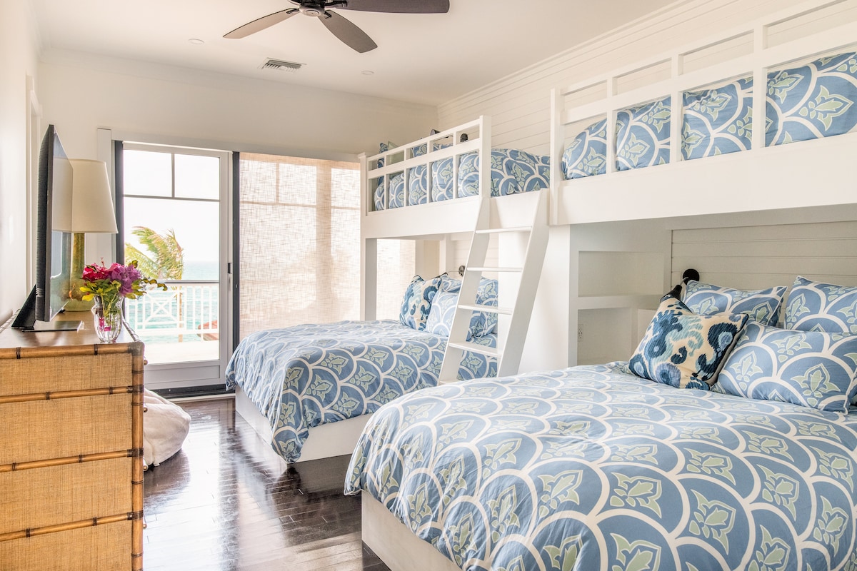 Dormitorio en la planta superior de la litera del océano. En la parte inferior 2 camas son Queens y las literas superiores son individuales. ¡Lleva a un balcón de segundo piso con vistas a la piscina y al mar! ¡Baño privado adjunto!