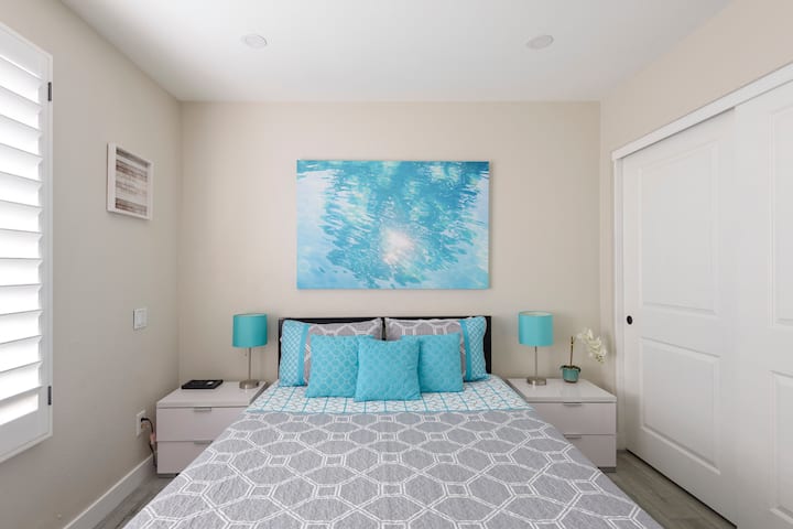 Queen Room with Plantation shutters, TV, closet.