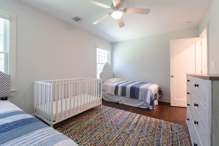 Sehr großes Gästezimmer mit Blick auf den Hinterhof mit zwei Einzelbetten und einem großen Kinderbett