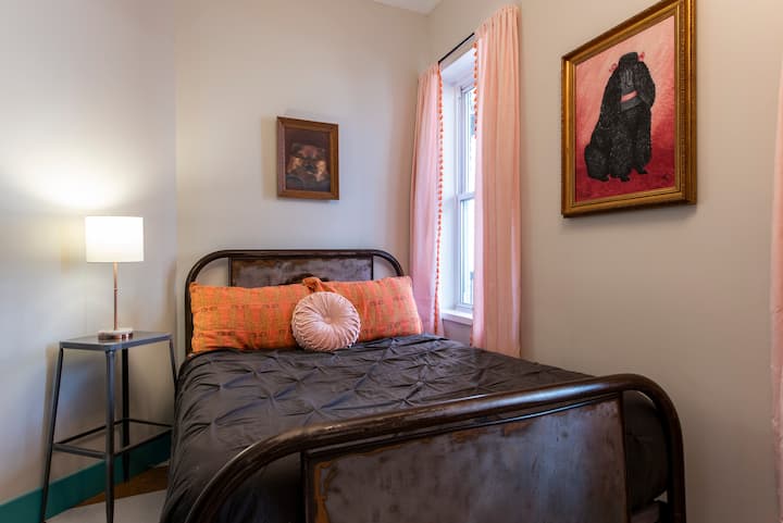 В една спалня има пълно легло със страхотна светлина.