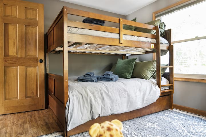 Кревети на спрат во целосна големина во спалната соба на главното ниво