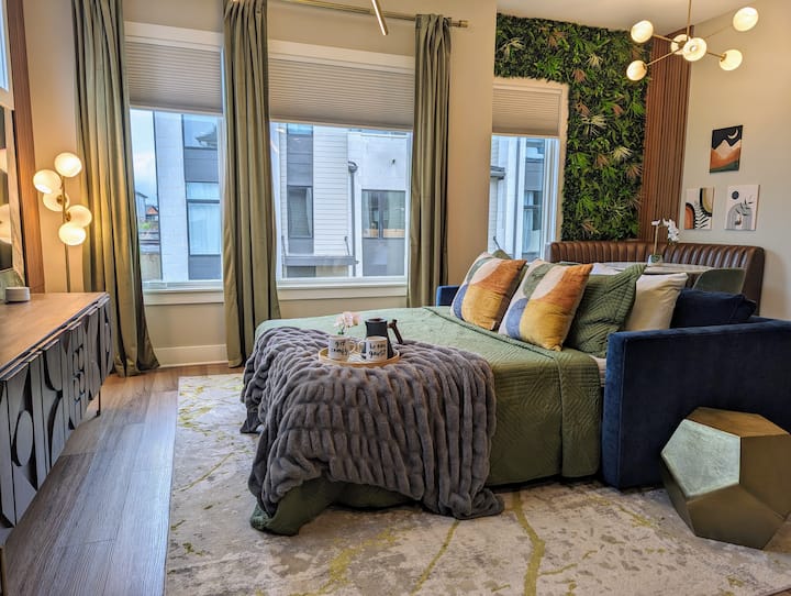 Разтегателен диван с двойно легло queen size, прибран и готов за употреба с чаршафи. Юрганът и възглавниците се съхраняват удобно във втората спалня на едно и също ниво, като предлагат гъвкавост и комфорт за допълнителни гости.