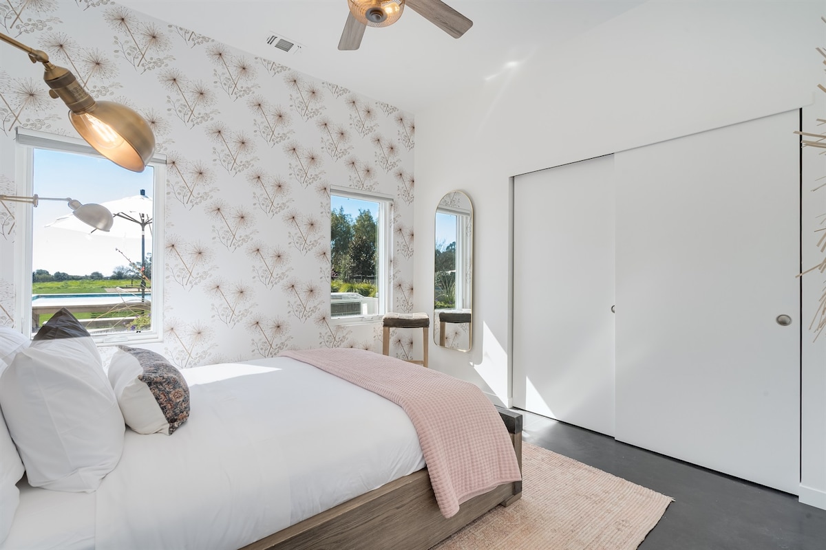 This beautiful stylish bedroom has a Restoration Hardware Queen Bed & Pool Views!